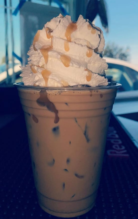 Iced caramel latte topped with whipped cream and caramel drizzle